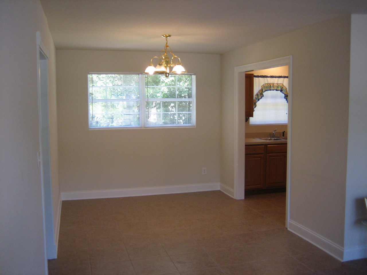 6943 Rollo Road Jacksonville, FL 32205 - Photo 7 of 13 an empty room with windows and chandelier