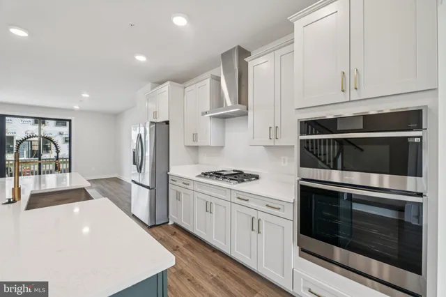 a kitchen with stainless steel appliances a stove a microwave and a refrigerator