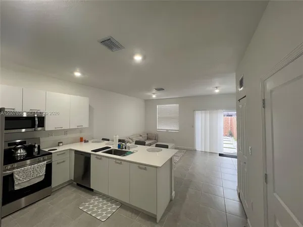a kitchen with a sink a counter top space stainless steel appliances and cabinets