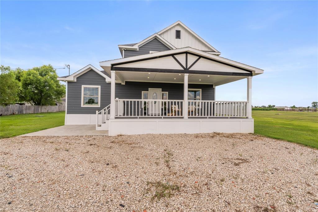 Gray siding exterior with white trim accents and a covered front porch featuring a decorative gable