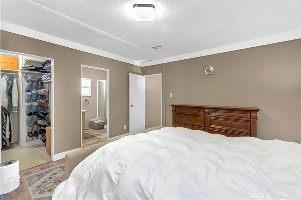 a bedroom with a bed and a large mirror