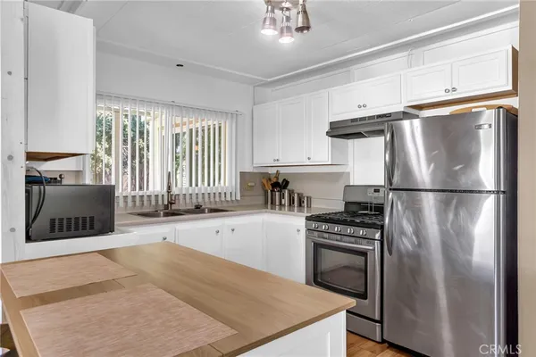 a kitchen with a refrigerator a stove and a sink