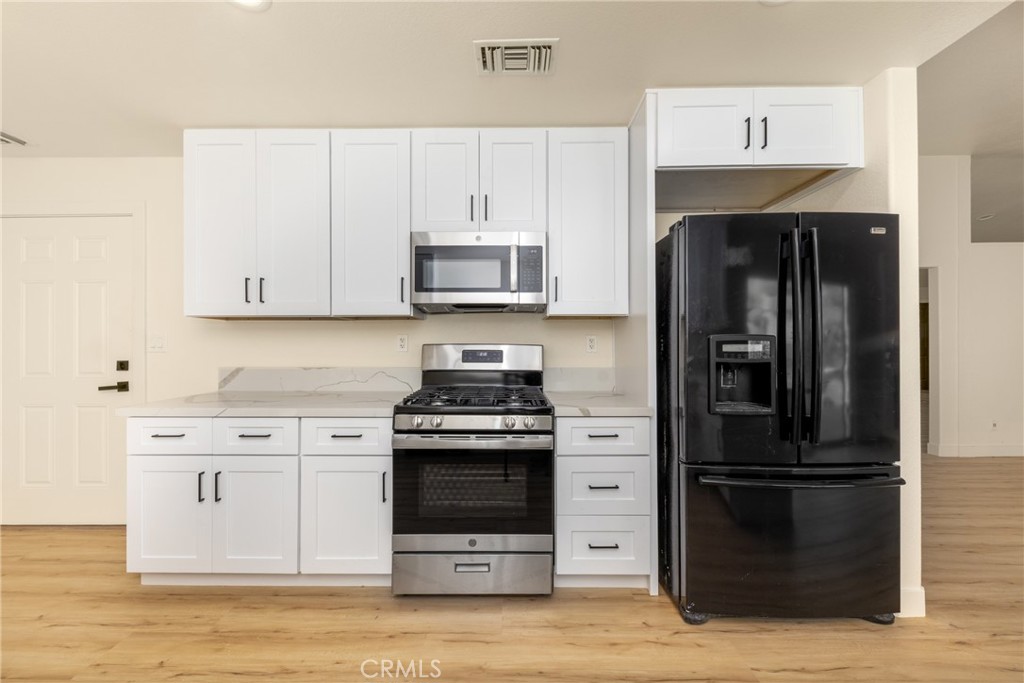 16322 Pick Place Riverside, CA 92504 - Photo 11 of 35 a kitchen with stainless steel appliances granite countertop a stove and a refrigerator