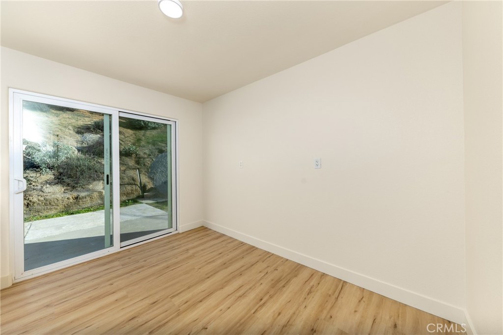 16322 Pick Place Riverside, CA 92504 - Photo 14 of 35 an empty room with wooden floor and windows