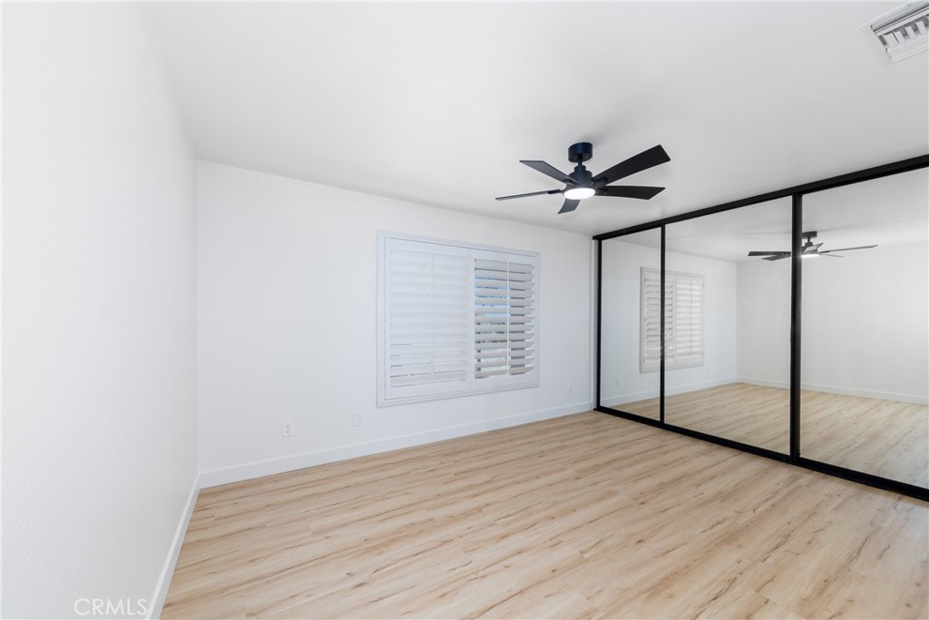 16322 Pick Place Riverside, CA 92504 - Photo 26 of 35 an empty room with wooden floor and ceiling fan