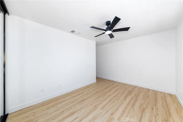 an empty room with a window and a fan