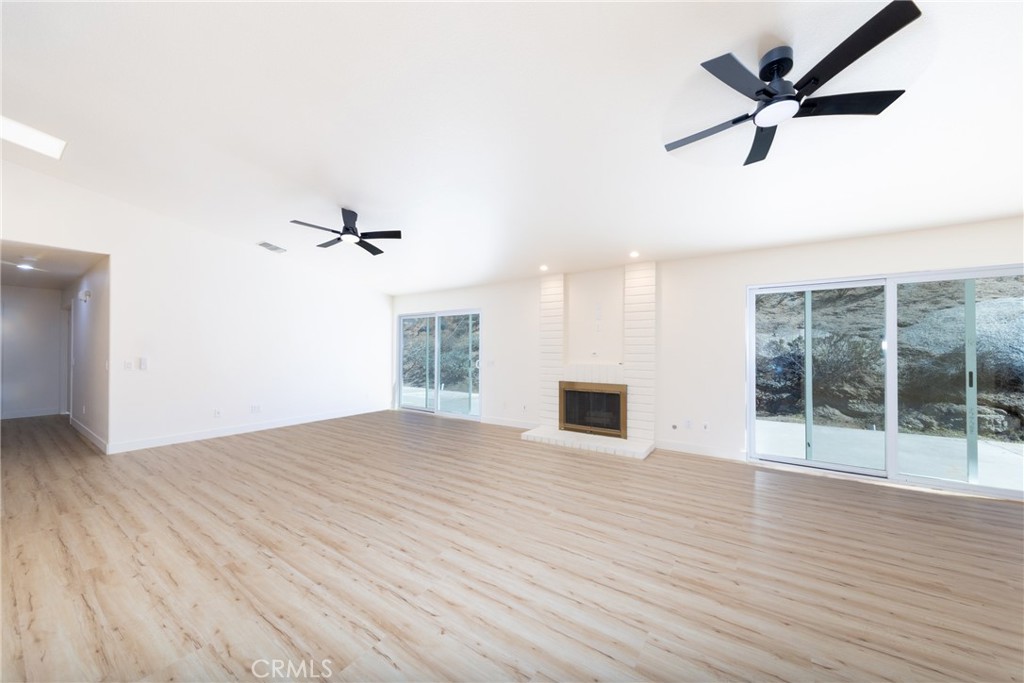 16322 Pick Place Riverside, CA 92504 - Photo 4 of 35 an empty room with wooden floor fan and windows