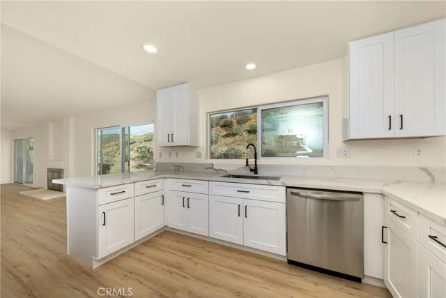 a kitchen with white cabinets sink and stove
