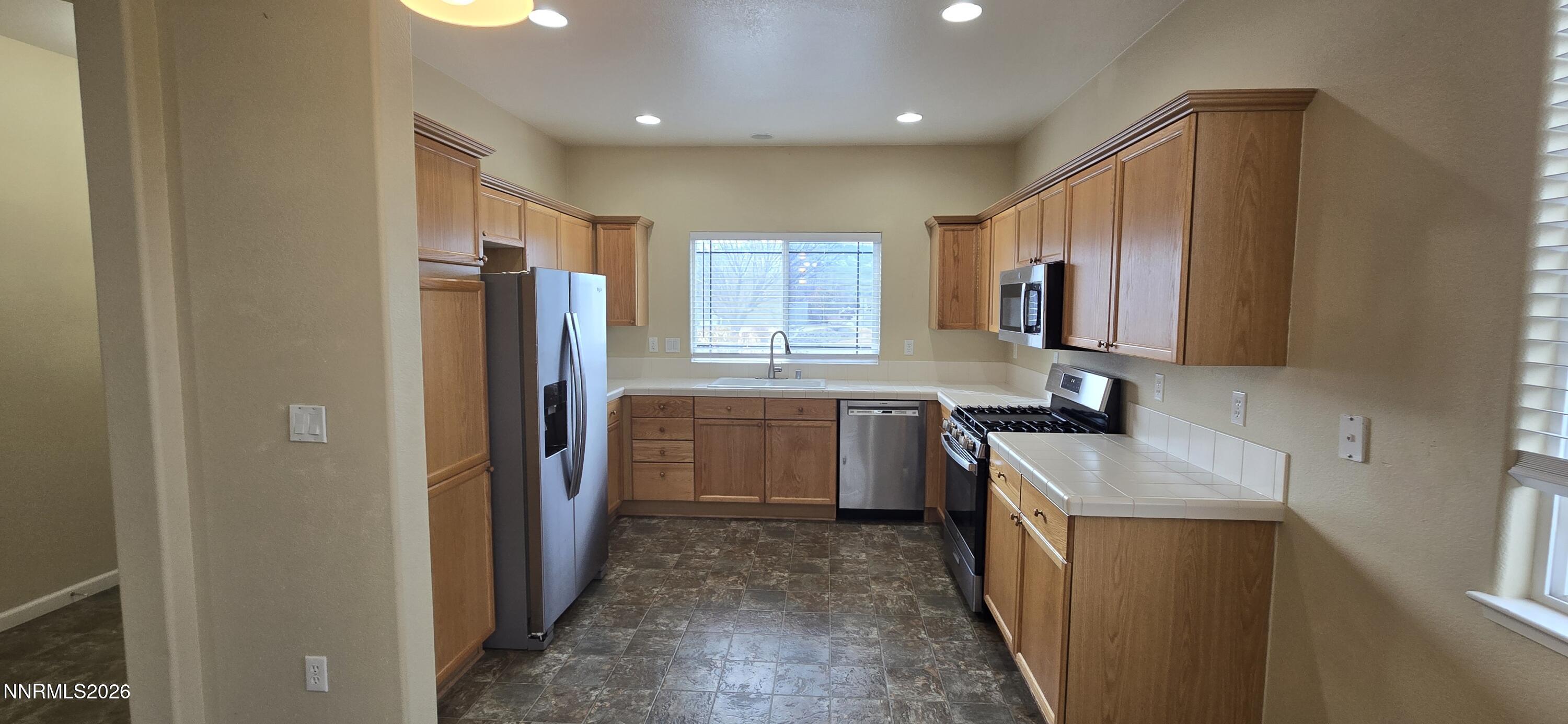 10210 Robilee Drive Reno, NV 89521 - Photo 17 of 56 a kitchen with a refrigerator sink stove and oven