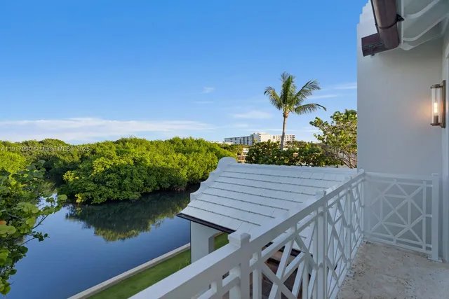 a front view of a house with a yard and potted plants