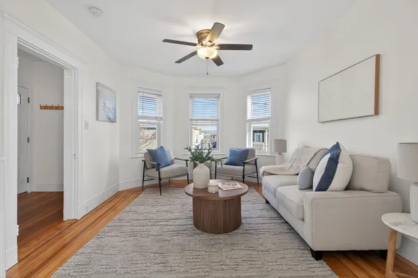 a living room with furniture and a wooden floor