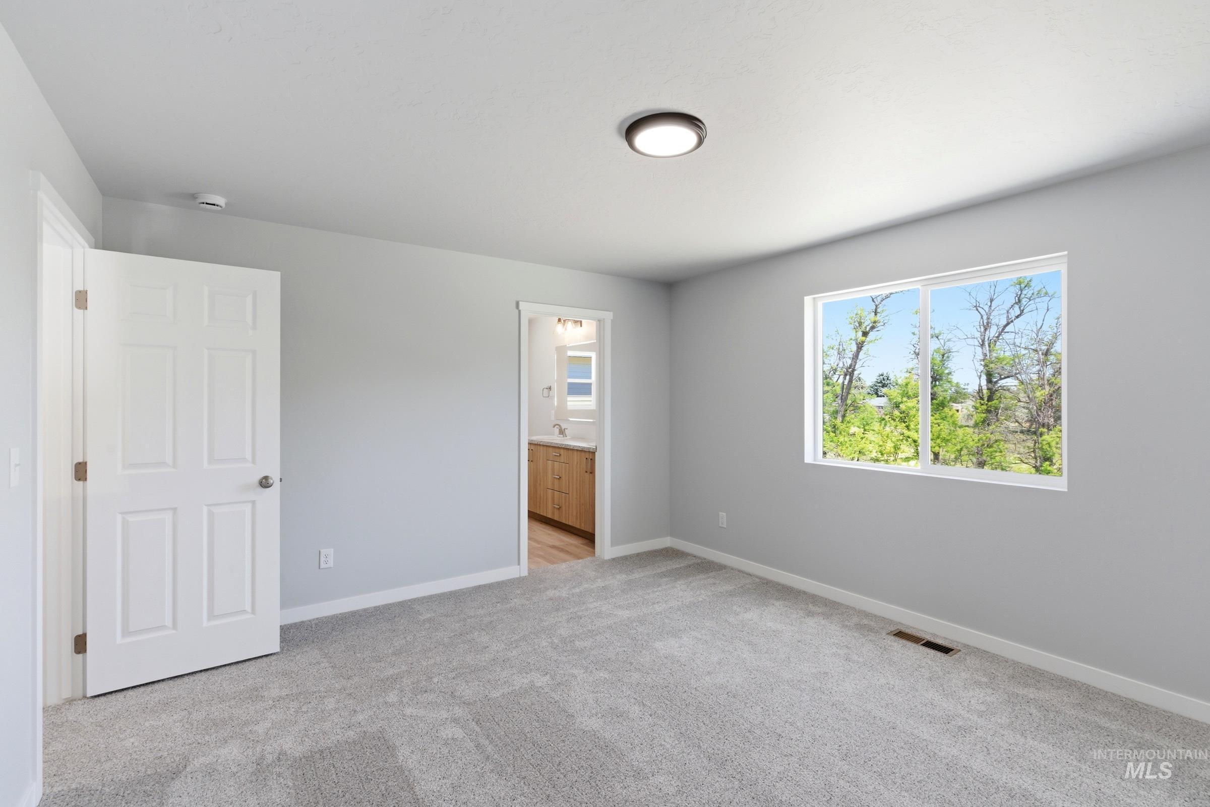 2374 West Fallon Loop Nampa, ID 83651 - Photo 20 of 24 Spacious room featuring light gray walls, plush gray carpeting, and a large window overlooking natural scenery
