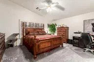 a spacious bedroom with a bed a mirror and windows