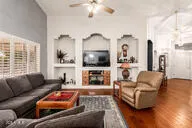a living room with furniture flat screen tv and wooden floor