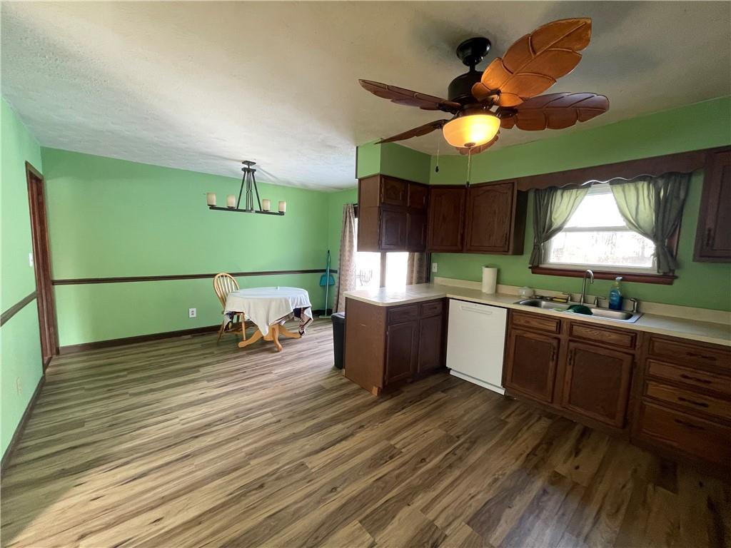 827 Georgetown Road Sandy Lake, PA 16145 - Photo 5 of 20 a kitchen with stainless steel appliances hardwood floor sink stove dining table and chairs