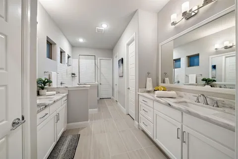 a large white kitchen with stainless steel appliances sink a stove and cabinets