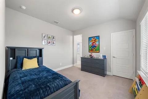 a bed room with a bed and a painting on the wall