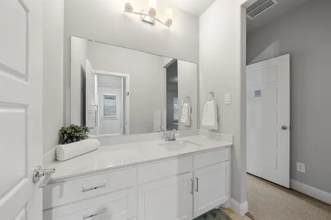 a bathroom with a sink vanity and a mirror