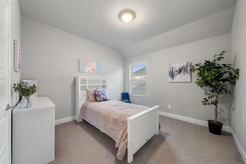 a bedroom with a bed and a potted plant