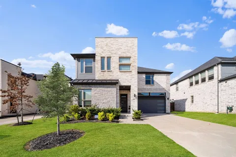 a front view of a house with a garden and yard