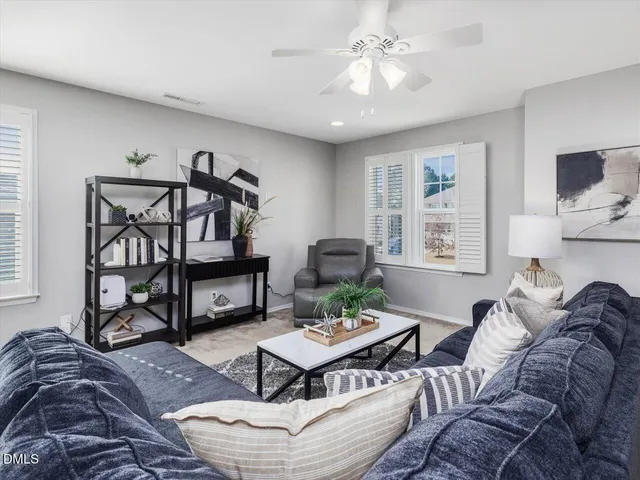 a living room with furniture and a ceiling fan