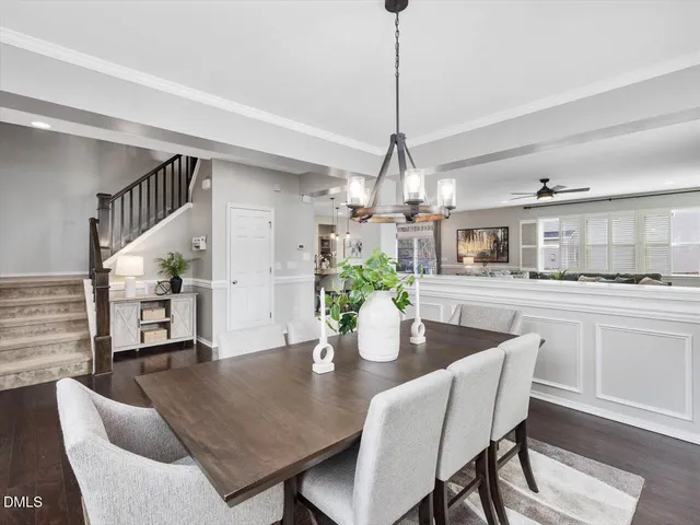 a open kitchen with stainless steel appliances granite countertop a stove a refrigerator a kitchen island a dining table and chairs with wooden floor