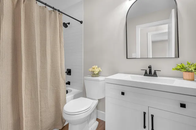 a bathroom with a sink vanity mirror and toilet