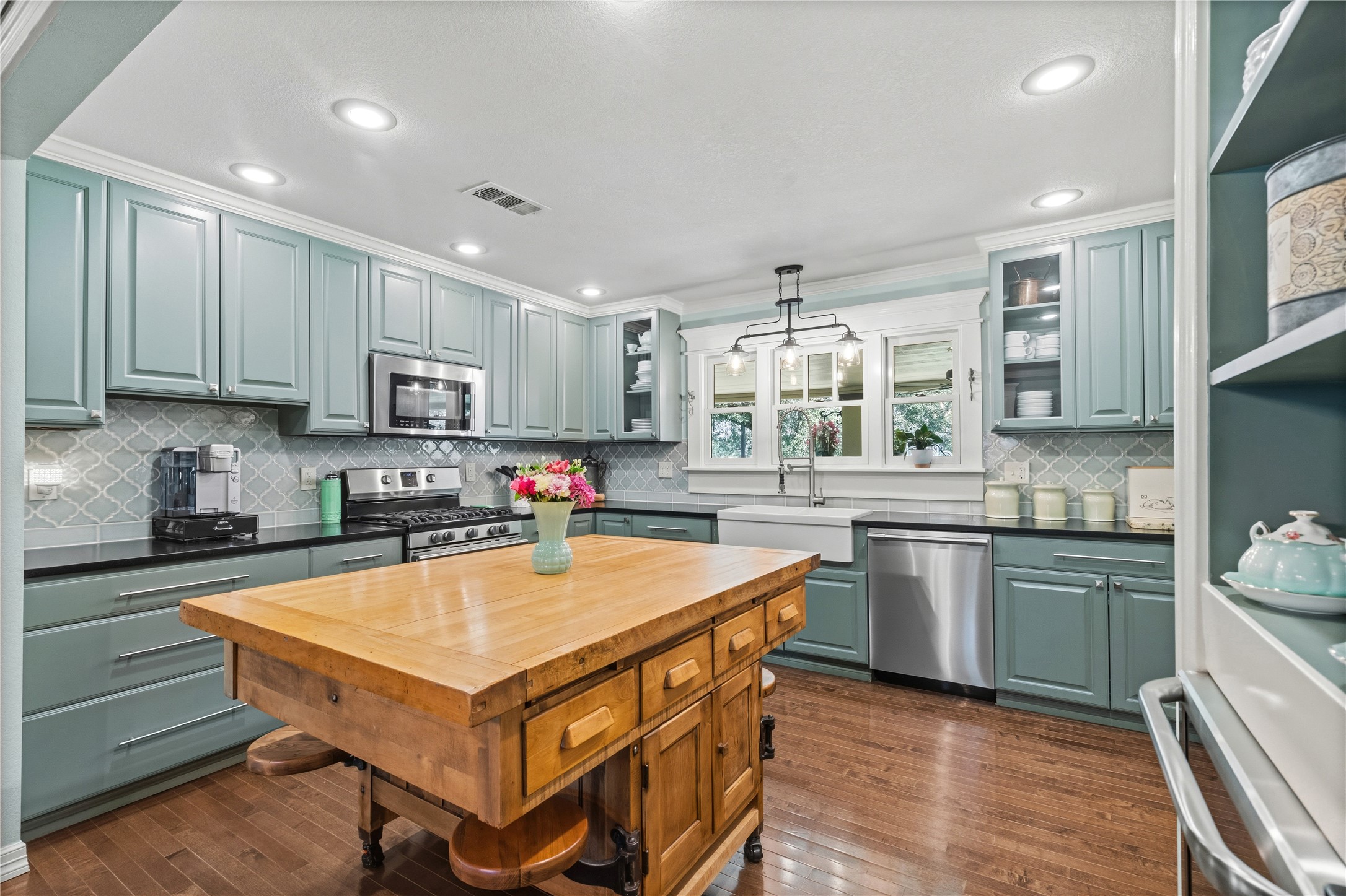 17821 Brown Road Conroe, TX 77306 - Photo 18 of 50 a kitchen with stainless steel appliances granite countertop a stove top oven a sink dishwasher and a refrigerator with wooden floor