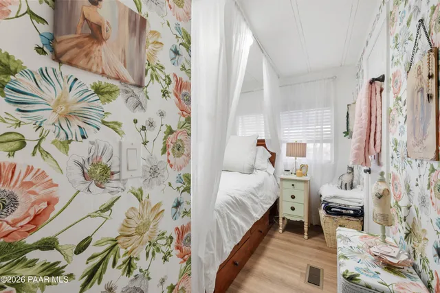 a bedroom with a bed and a painting on the wall