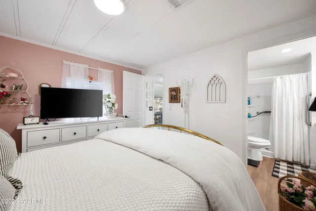 a bedroom with a bed and a flat screen tv