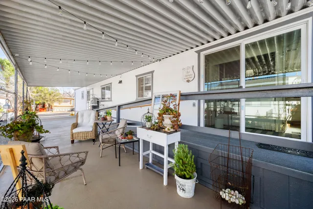 a view of a porch with chairs and potted plants