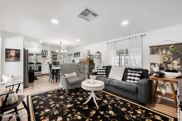 a living room with furniture and a dining table with kitchen view