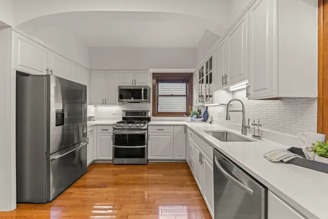 a kitchen with stainless steel appliances a sink stove refrigerator and cabinets
