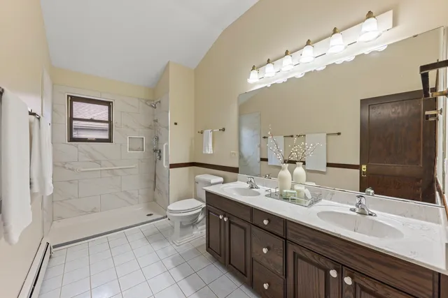 a bathroom with a double vanity sink mirror and shower