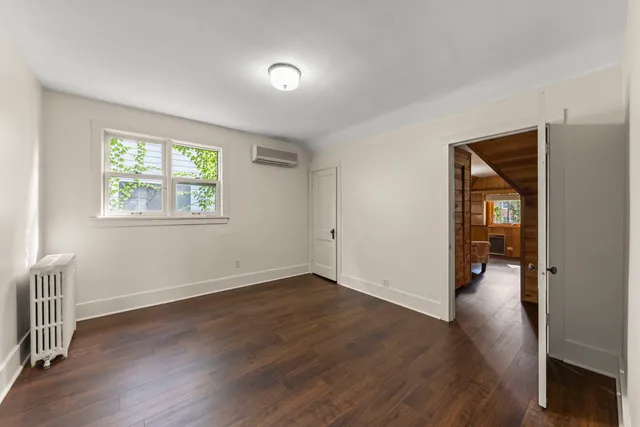 an empty room with wooden floor and a window