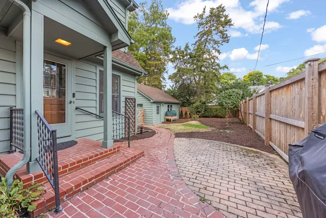 a view of a house with backyard and sitting area