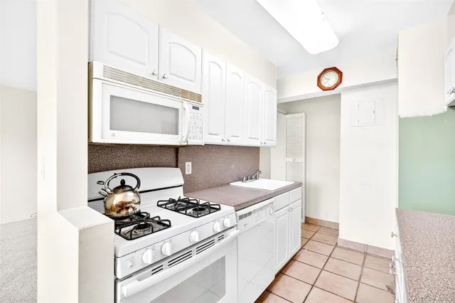 a hallway with a view of kitchen cabinetry and a window