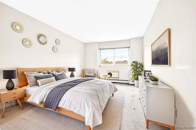a bedroom with a large bed and a flat tv screen on dresser
