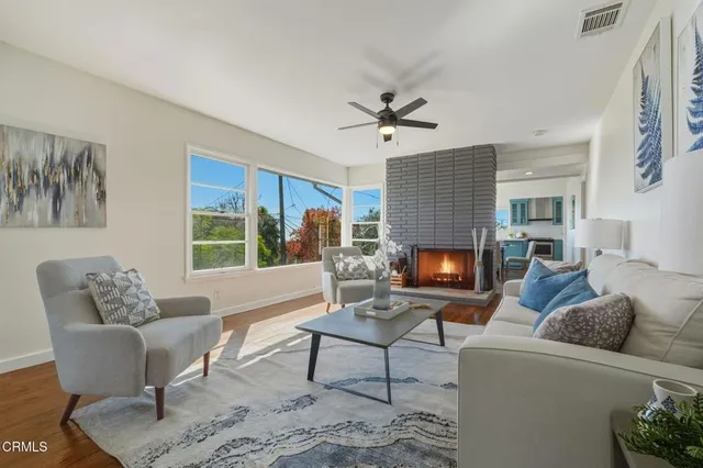 a living room with furniture a fireplace and a large window