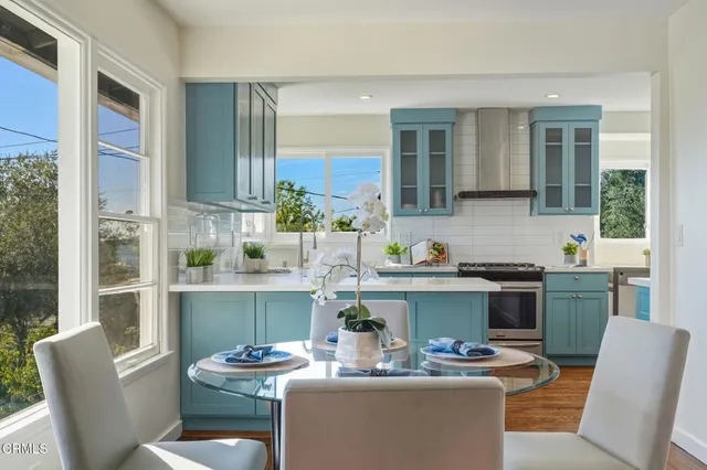 a kitchen with a dining table chairs stove and kitchen view