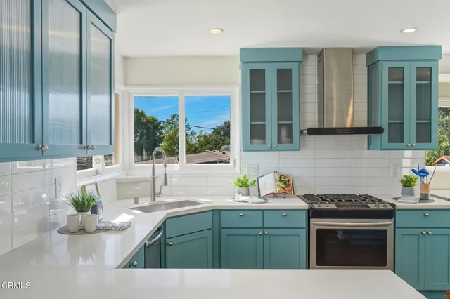a kitchen with stainless steel appliances kitchen island granite countertop a sink stove and cabinets