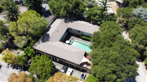 an aerial view of a house with a yard and trees