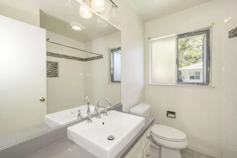 a bathroom with a sink a toilet and shower