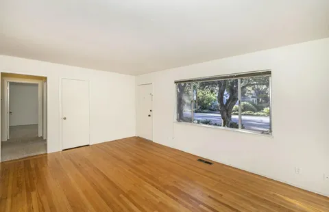 wooden floor in an empty room with a window