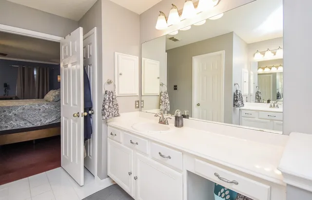 a spacious bedroom with a bed and a flat screen tv