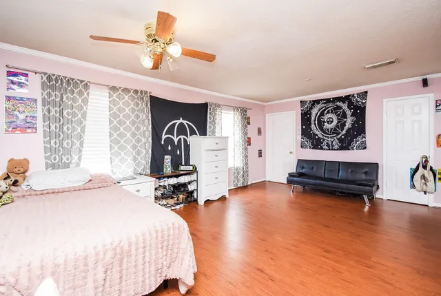 a bedroom with furniture and wooden floor