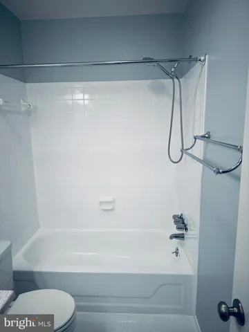 a bathroom with a shower and a white bath tub