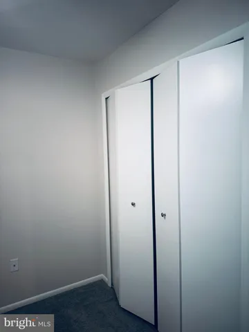 a view of an empty room with a ceiling fan and window