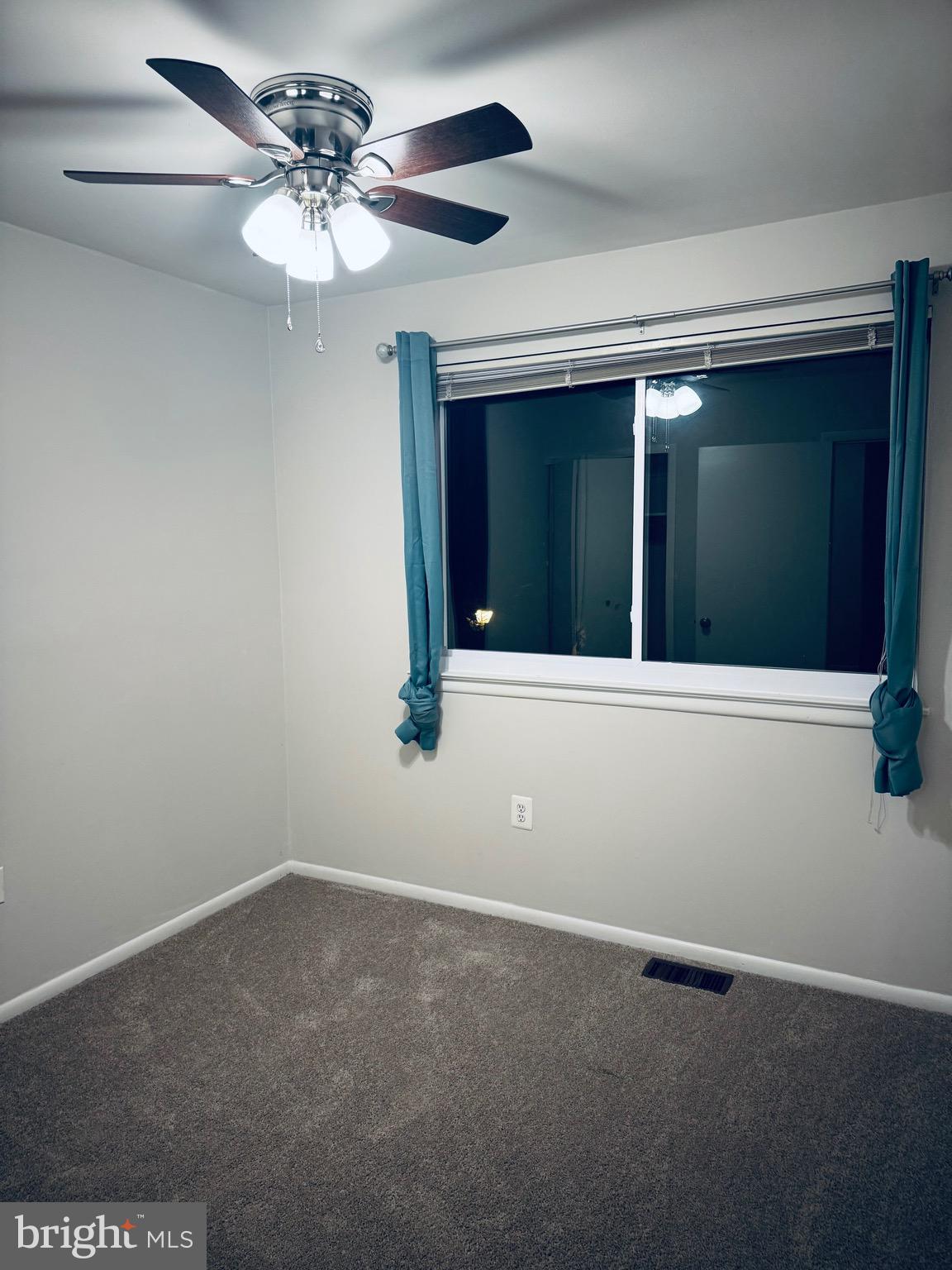 15839 Millbrook Lane, Unit 122 Laurel, MD 20707 - Photo 17 of 19 a view of an empty room with a ceiling fan and window