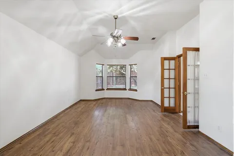 a spacious bedroom with a bed a chandelier and a potted plant
